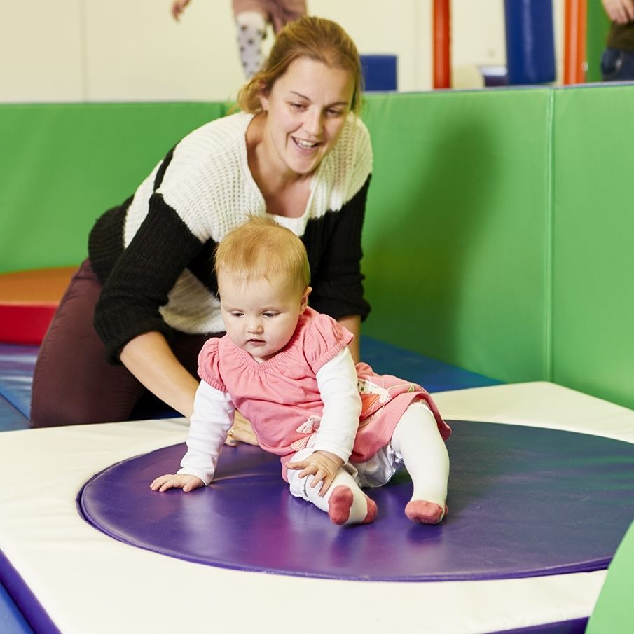 Mother helping child using the SensaSoft Sit 'N Spin for sensory play