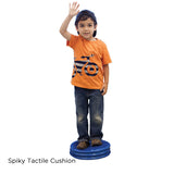child standing on the spiky tactile cushion