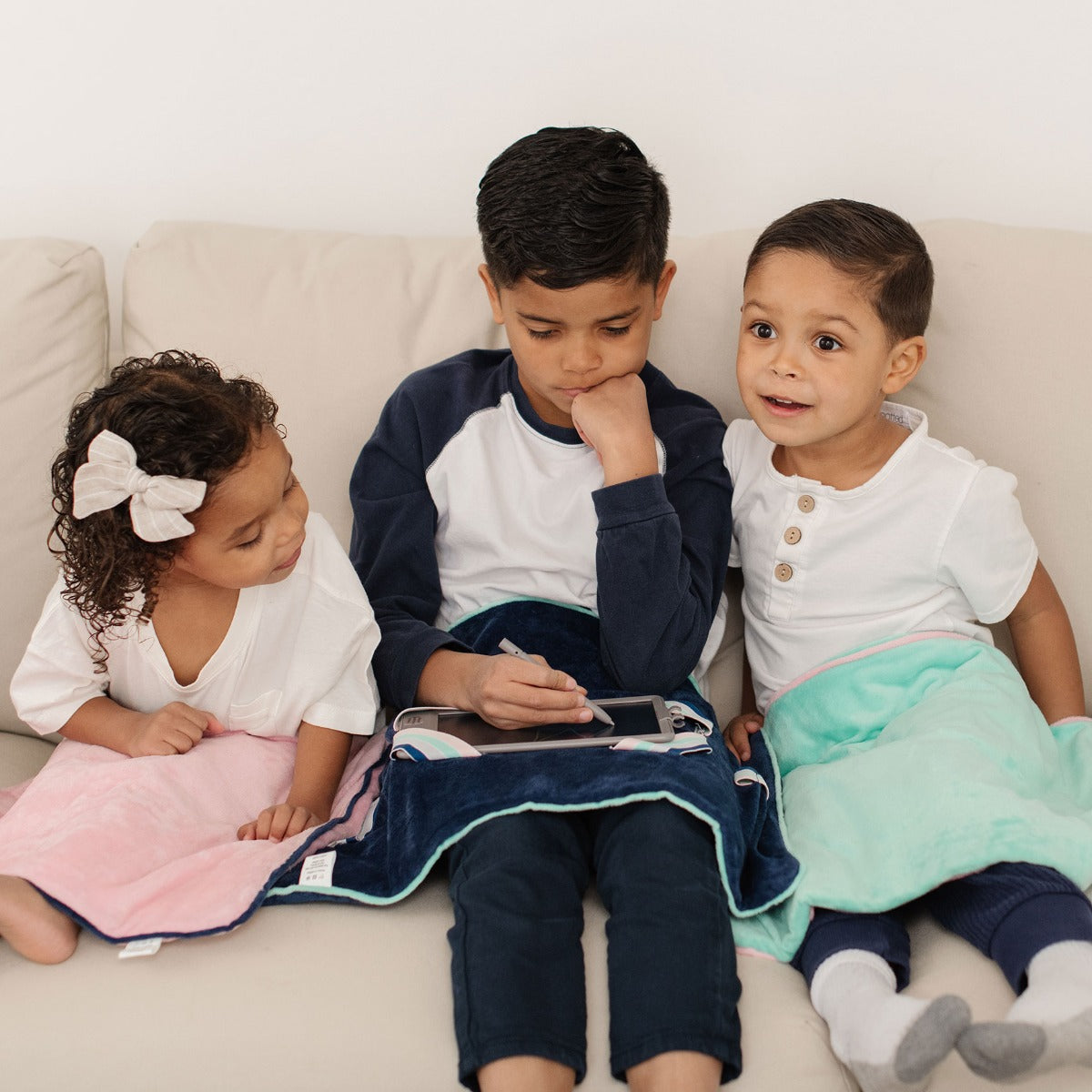 Three children using the Sensory Basics Weighted Lap Pads